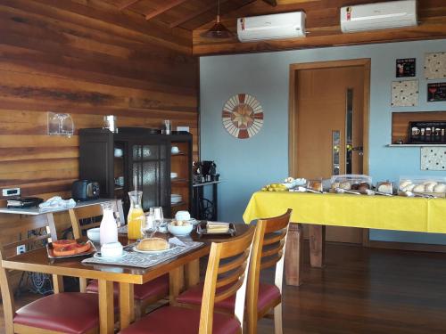 a dining room with a table with a yellow table cloth at Pousada Vale Do Comandante in Macacos