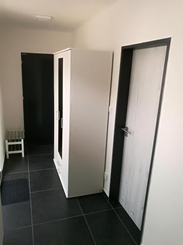 a hallway with two white doors and a tile floor at Haas Apartments Downtown with Parking in Brno