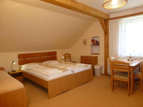 een slaapkamer met een bed, een bureau en een tafel bij U Votápků in Nové Hutě