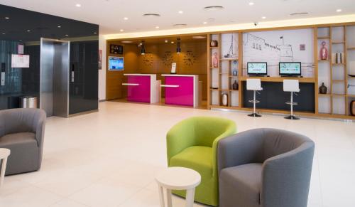 a lobby with chairs and tables in a building at ibis Styles Manama Diplomatic Area in Manama