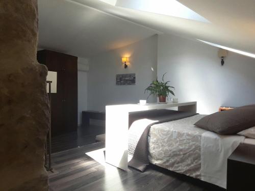 a bedroom with a bed and a table with a plant at Apartamentos Sol de Mayo in Úbeda