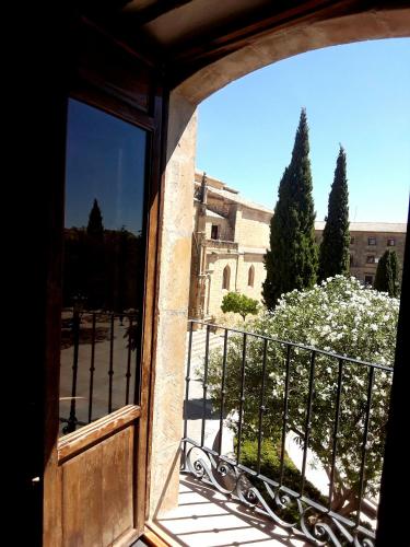 an open door to a balcony with a view of a building at Apartamentos Sol de Mayo in Úbeda