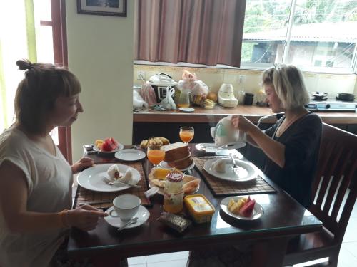 two women sitting at a table eating breakfast at Grand Resort in Kandy