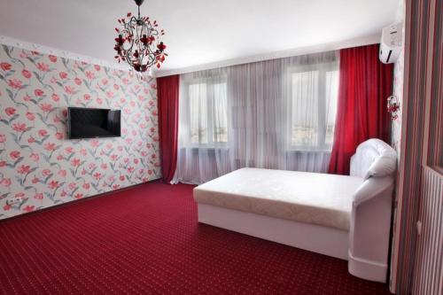 a bedroom with a white bed and a red carpet at Vip-Parus in Kharkiv