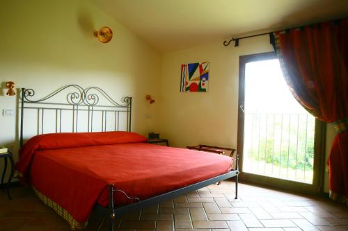 een slaapkamer met een bed en een groot raam bij Campastrello Sport Hotel Residence in Castagneto Carducci