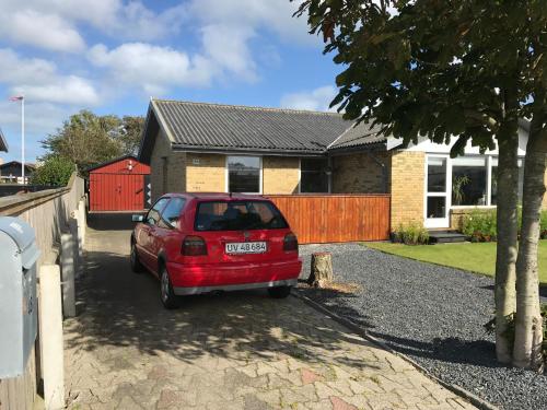a red car parked in front of a house at Skagen Annex Apartment in Skagen
