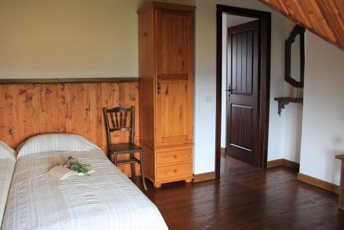 a bedroom with a bed and a chair and a door at Villa Zoryany Dvir in Skhidnitsa