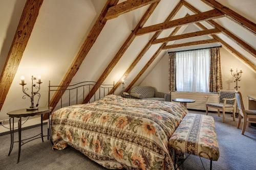 a bedroom with a bed and a table and chairs at Parkhotel Schwert in Weesen