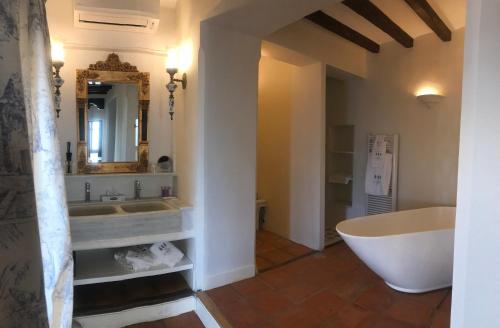 a bathroom with a tub and a sink and a mirror at Casa Palacio VillaZambra in Ronda