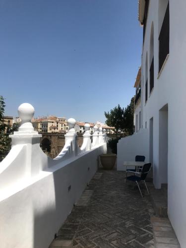 a balcony with white walls and a chair at Casa Palacio VillaZambra in Ronda