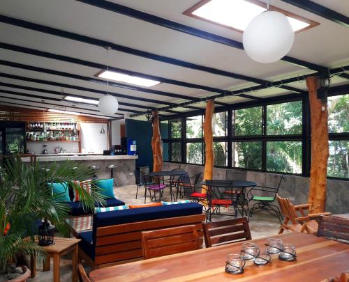 a restaurant with tables and chairs and windows at Xalli Beach Hotel in Altagracia