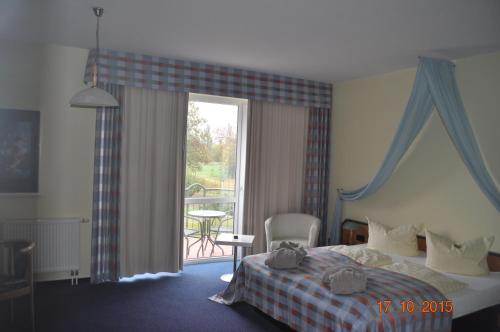 a hotel room with a bed and a balcony at Turmhotel Schwedt in Schwedt