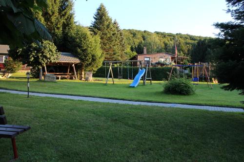 un parque con parque infantil con tobogán en Ferienhäuser "Zur Hohen Sonne", en Thale