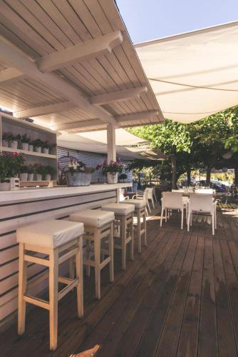 a row of tables and chairs on a patio at Teatro Deluxe Rooms in Kato Rodini