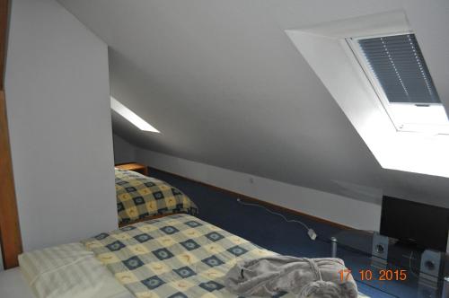 an attic room with a bed and a window at Turmhotel Schwedt in Schwedt