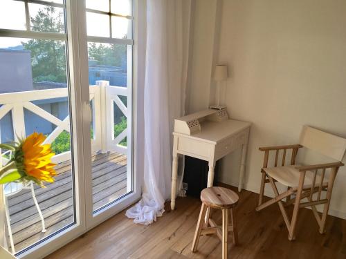 a room with a balcony with a desk and a window at Zimmer mit Bad und Balkon in Widen