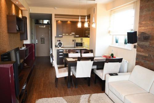 eine Küche und ein Wohnzimmer mit einem Tisch und Stühlen in der Unterkunft Panorama Penthouse Siófok in Siófok