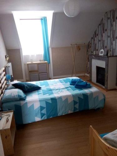 une chambre avec un lit avec une couette bleue dans l'établissement La Tourelle en Normandie, à Saint-Pierre-Église