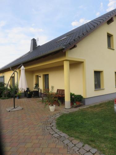 een huis met een patio en een parasol bij Haus am Park in Thallwitz