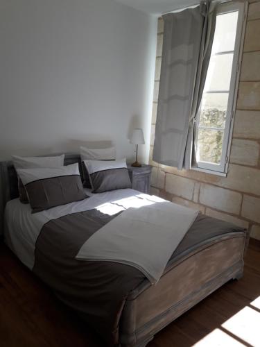 un grande letto in una camera da letto con finestra di Entre Estuaire et Citadelle a Blaye