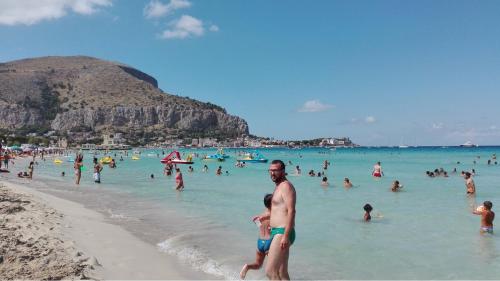 a group of people in the water at a beach at Halley House in Mondello