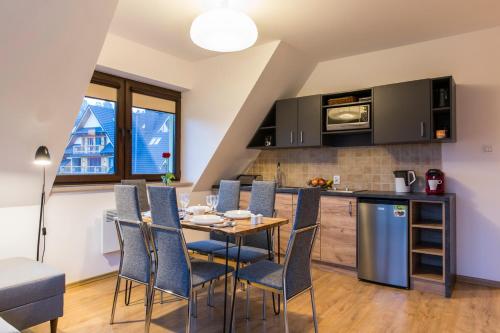 a kitchen and dining room with a table and chairs at Banialuka Apart in Białka Tatrzańska