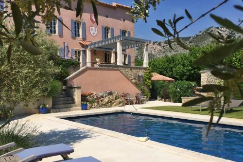 ein Haus mit einem Swimmingpool vor einem Gebäude in der Unterkunft Château de la Merletade in Cheval-Blanc