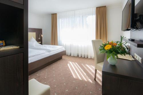 a hotel room with a bed and a window at Hotel Landgasthof Birkenfelder Hof in Birkenfeld