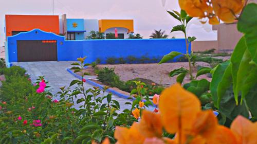 a garden with a blue fence and flowers at Villa Star of the Sea in Barra de Navidad