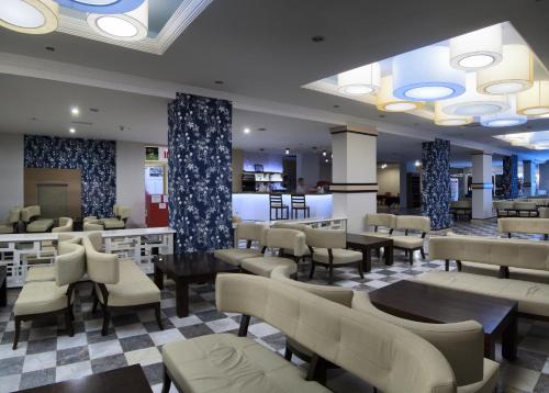 a restaurant with tables and chairs and a lobby at Ephesia Hotel - All Inclusive in Kusadası