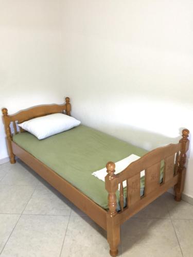 una cama de madera con una almohada encima en Apartments Vali, en Ulcinj