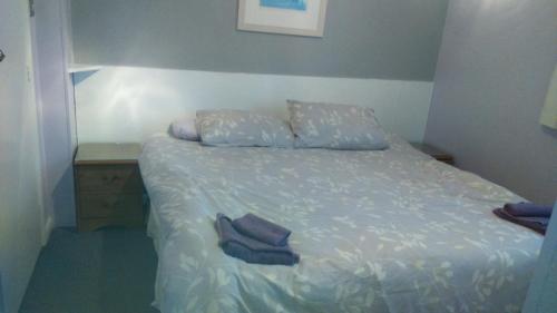 a bed with two pillows and two towels on it at Smugglers Rest in Newquay