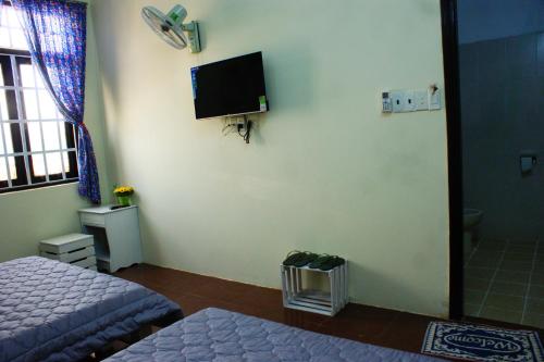 a bedroom with a bed and a tv on the wall at Hotel An Nhien in Buon Ma Thuot