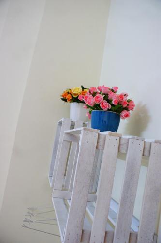 a blue pot on top of a ladder with flowers on it at Hotel An Nhien in Buon Ma Thuot