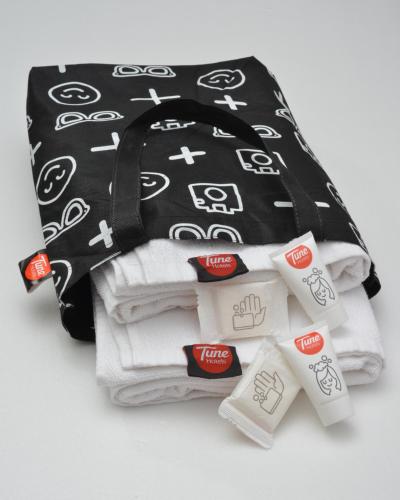 a pile of towels and a black and white bag at D'concept Hotel Kulim in Kulim
