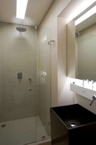 a bathroom with a glass shower and a sink at O&B Athens Boutique Hotel in Athens