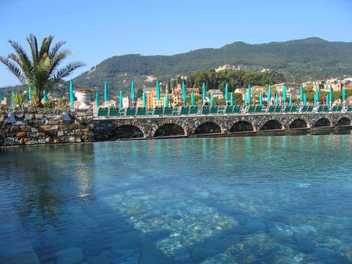 a bridge over a body of water with flags at Hotel Helios in Santa Margherita Ligure