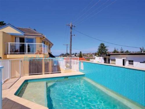 a large swimming pool in front of a house at Ocean Pines Apartments 4 in The Entrance