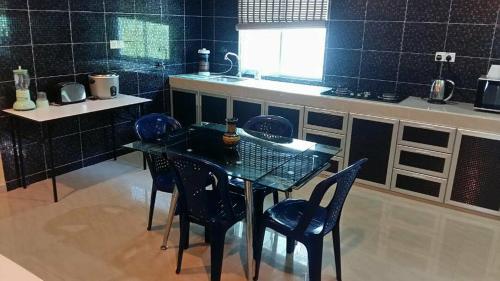 een keuken met een tafel en stoelen en een aanrecht bij Port Dickson Holiday Home Villa in Port Dickson