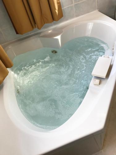 a bath tub filled with blue water in a toilet at Super 8 by Wyndham Kindersley in Kindersley