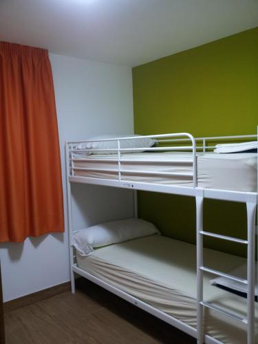 a room with two bunk beds and an orange curtain at Pensión San Fermín in Donostia-San Sebastián