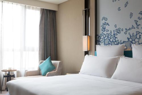 a hotel room with two beds and a window at Pullman Taiyuan in Taiyuan