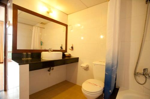 a bathroom with a toilet and a sink and a mirror at Dam San Hotel in Buon Ma Thuot