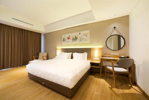 a bedroom with a bed and a desk and a mirror at Aviary Bintaro in Serpong