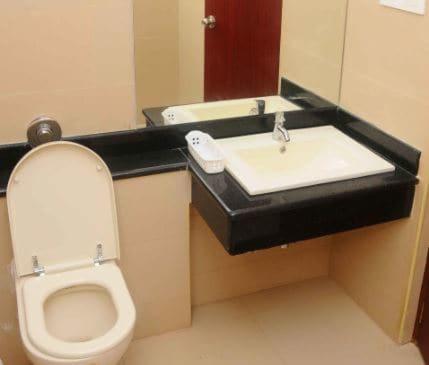 a bathroom with a toilet and a sink at Hotel Sriram JB Residency in Virudunagar
