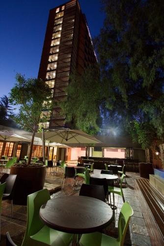 a restaurant with tables and chairs and a tall building at Hotel 224 & Apartments in Pretoria