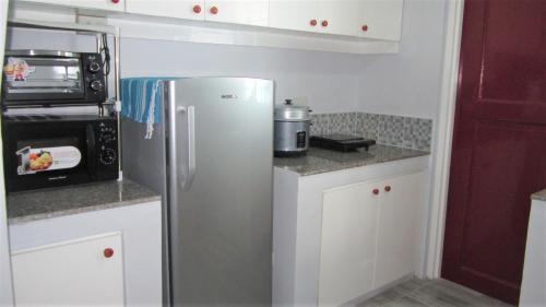 a small kitchen with a stainless steel refrigerator at Homestay at 24 Laguna Bel-Air by Red Door House Rental in Santa Rosa
