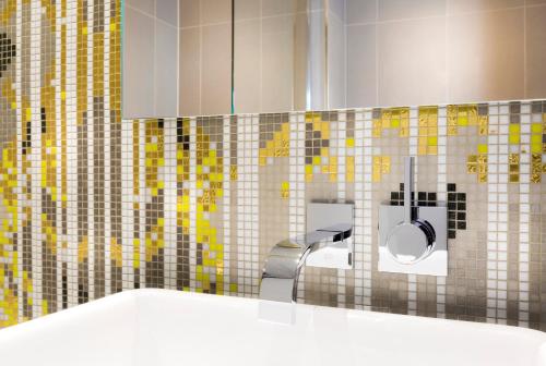ein Badezimmer mit einem Waschbecken, einem WC und einem Spiegel in der Unterkunft Vendôme Opera Hotel in Paris