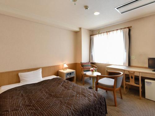 a hotel room with a bed and a desk at Hotel Pearl City Sapporo in Sapporo