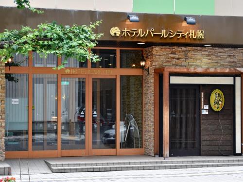 a building with glass doors and a sign on it at Hotel Pearl City Sapporo in Sapporo